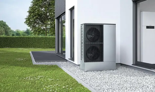 Außeneinheit einer Wärmepumpe am Haus im Gartenbereich