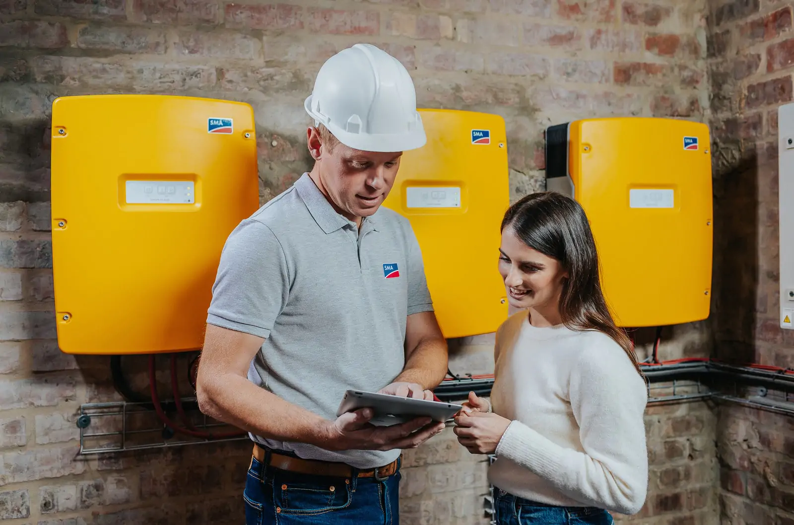 Kundenberatung zur Energieanlage vor drei Wechselrichtern